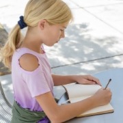 young girl writing in journal | Sunset Vacations