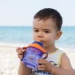Baby drinking water on beach | Sunset Vacations