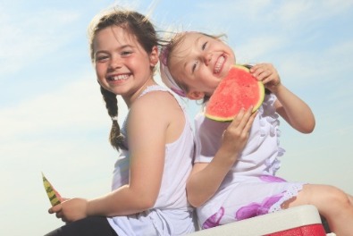 Kids having watermelon on the beach | Sunset Vacations
